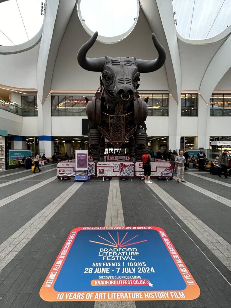 A BLF floor vinyl in front of 'Ozzy the Bull' at Birmingham New Street station